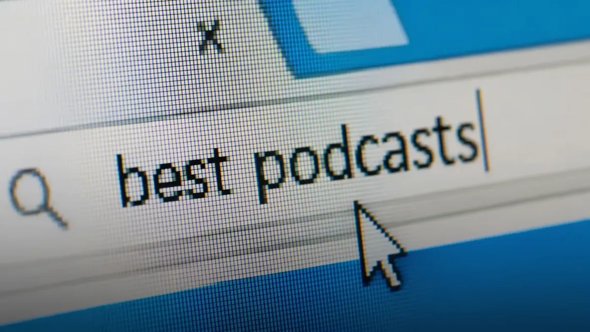Close-up of a browser search bar with best podcasts typed in and a mouse cursor below it